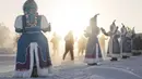 Wanita berkostum nasional Yakutian mendukung pelari yang sedang ambil bagian dalam maraton terdingin di dunia internasional pada suhu minus 53 derajat (-63,4 Fahrenheit) di dekat Oymyakon, republik Sakha, juga dikenal sebagai Yakutia, Timur Jauh Rusia, Sabtu, 22 Januari 2022. (AP/Ivan Nikiforov)
