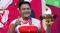 Atlet ParaCycling, Soemantri menggigit medali perunggu nomor Mens H4-5 Individual Time Trial Road Race Asian Para Games 2018 di Sirkuit Sentul, Bogor, Senin (8/10). Soemantri berhasil merebut medali perunggu. (Liputan6.com/Helmi Fithriansyah)