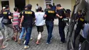 Petugas membawa salah satu komplotan pencuri spesialis rumah kosong saat rilis di Halaman Polrestabes Semarang , Minggu ( 19/6). Menjelang lebaran kejahatan pencurian rumah kosong meningkat. (Gholib)