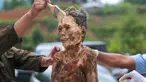 Keluarga membersihkan jenazah kerabat yang diawetkan saat ritual adat Manene di Desa Pangala, Toraja Utara, Sulawesi Selatan, 27 Agustus 2021. Manene merupakan upacara turun temurun masyarakat Toraja sebagai bentuk penghormatan kepada leluhur mereka yang telah wafat. (SEVIANTO PAKIDING/AFP)