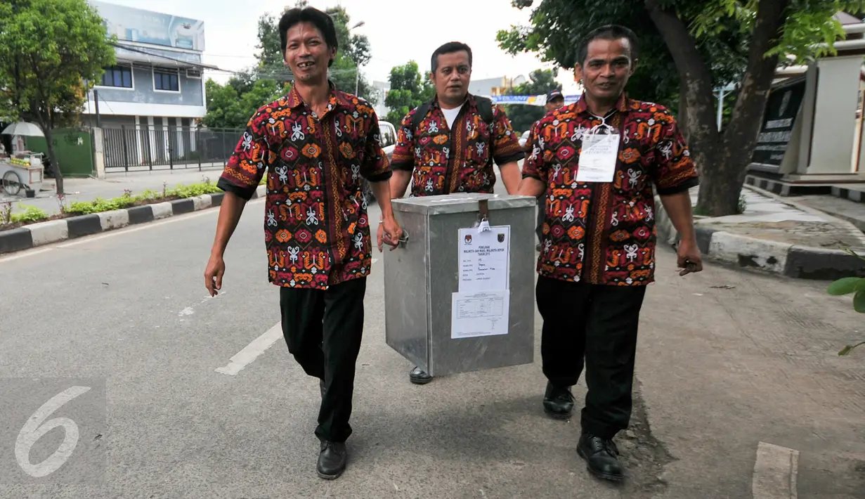 Petugas TPS membawa kotak suara yang nantinya akan dikumpulkan ke kelurahan sebelum didistribusikan kembali ke Kecamatan, Depok, (9/12). TPS di Kota Depok adalah sebanyak 3.235 TPS tersebar di 63 kelurahan dan 11 kecamatan. (Liputan6.com/Yoppy Renato)