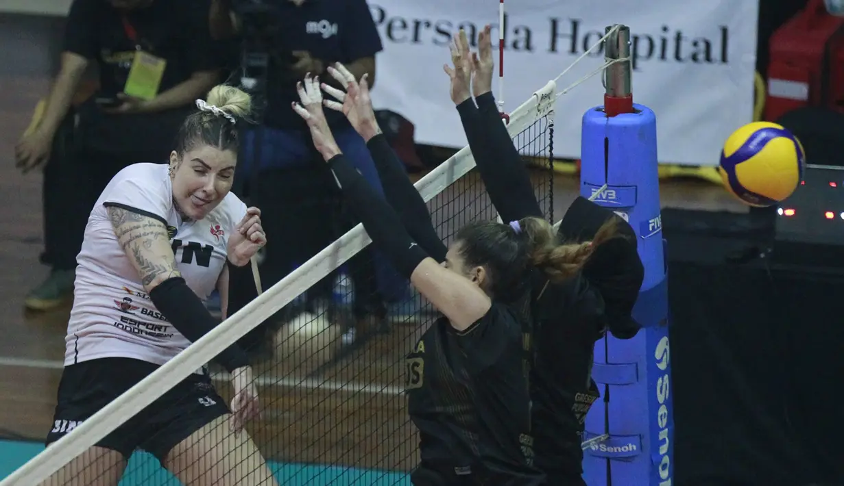 Pemain Jakarta BIN, Fernanda Davis Tome melepaskan spike yang berusaha diblok dua pemain Gresik Petrokimia Pupuk Indonesia dalam laga seri kedua putaran kedua Proliga 2023 di GOR Ken Arok, Malang, Kamis (9/2/2023) siang WIB. Jakarta BIN kalah 2-3 (25-23, 21-25, 25-20, 17-25 dan 9-15). (Dok. Proliga 2023)