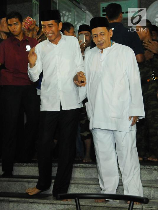 Capres nomor urut 01 Joko Widodo atau Jokowi (kiri) menggandeng Habib Luthfi bin Yahya usai menjalankan ibadah dalam kampanye terbuka di Alun-Alun Brebes, Jawa Tengah, Kamis (4/4). Jokowi menargetkan kemenangan lebih dari 80 persen di Brebes. (Liputan6.com/Angga Yuniar)