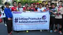 Sejumlah warga berfoto bersama dengan Ketua Kwartir Nasional (Kwarnas) Gerakan Pramuka Adhyaksa Dault sambil memegang spanduk saat aksi Satu Indonesia di area CFD, Bundaran HI, Minggu (30/7). (Liputan6.com/Helmi Afandi)