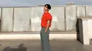 Photoshoot dengan pesona yang tak main-main. Kim Soo Hyun tampil mengenakan kemeja lengan pendek yang digulung ke atas berwarna oranye, dipadunya memakai celana panjang kain berwarna abu-abu dan sneakers putih. [Foto: Instagram/soohyun_k216]