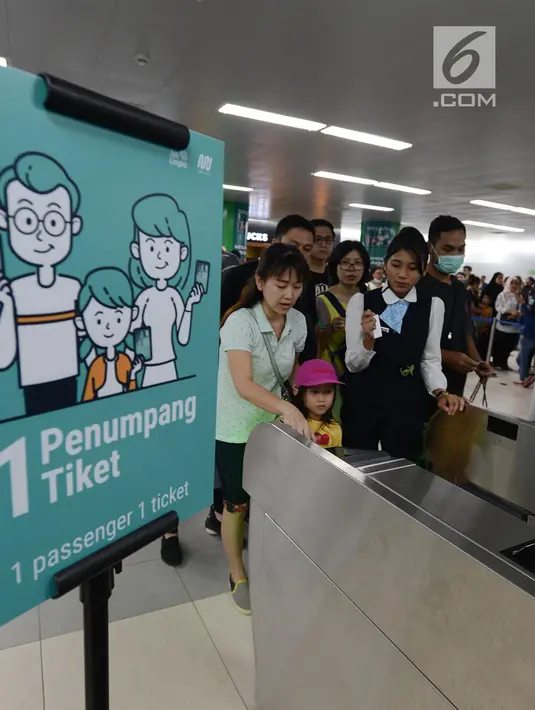 Petugas membantu calon penumpang melakukan tap kartu saat akan menggunakan layanan transportasi Moda Raya Terpadu (MRT) di Stasiun Bundaran HI, Jakarta, Rabu (3/4). Layanan MRT dimulai pukul 05.30 WIB hingga 22.01 WIB. (merdeka.com/Imam Buhori)