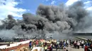 Petugas pemadam kebakaran dibantu pekerja mencoba memadamkan api di kapal nelayan di Pelabuhan Benoa, Denpasar, Bali, Senin (9/7). Kebakaran terjadi pada pukul 02.00 Wita. (SONNY TUMBELAKA/AFP)