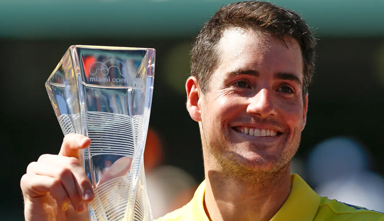 Petenis AS, John Isner memegang trofi Miami Terbuka 2018 usai mengalahkan petenis Jerman Alexander Zverev, Minggu (1/4). Isner menjadi petenis tertua yang memenangkan gelar turnamen Masters 1000 untuk kali pertama. (Michael Reaves/GETTY IMAGES/AFP)