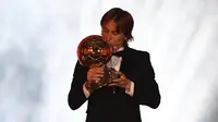 Gelandang Real Madrid, Luka Modric mencium trofi setelah memenangkan penghargaan Ballon d'Or 2018 pada malam penganugerahan di Paris, Senin (3/12). Penghargaan individu ini menjadi gelar Ballon d'Or pertama sepanjang karier Modric. (FRANCK FIFE/AFP)