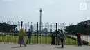 Warga berdiri di depan pagar Monumen Nasional (Monas), Jakarta, Sabtu (15/5/2021). Warga kecewa lantaran tempat wisata tersebut ditutup, padahal mereka datang untuk menikmati libur Idul Fitri 1442 Hijriah. (merdeka.com/Imam Buhori)