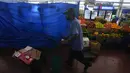 Seorang pekerja mendorong boneka melewati kios yang tutup di sebuah pasar di Panama City, Rabu (20/7/2022). Protes minggu ketiga dan blokade jalan raya mulai berdampak pada pasokan makanan dan barang-barang lainnya di beberapa bagian Panama. (AP Photo/Arnulfo Franco)