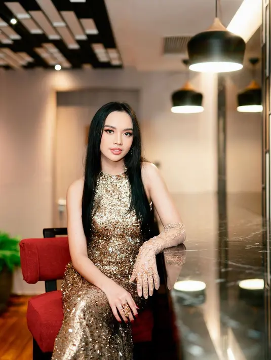 Gaya glamor Lyodra Ginting dibalut shimmer sleeveless dress warna emas yang berkilau.  [@lyodraofficial]
