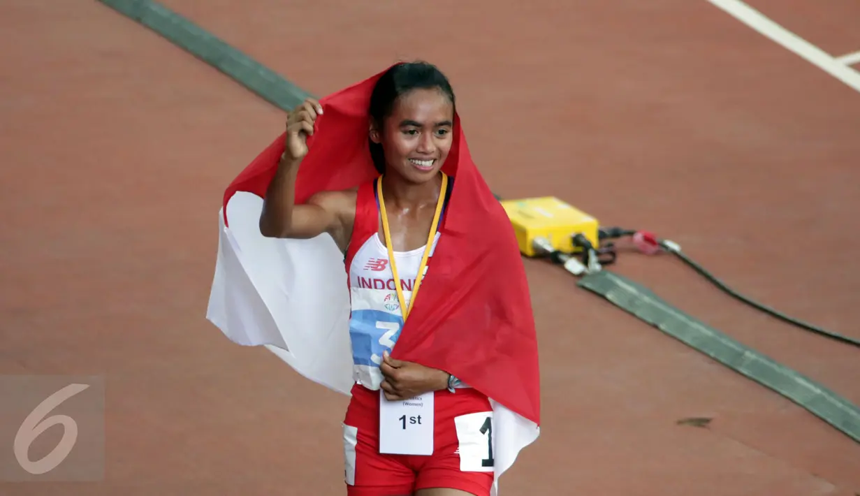 Atlet putri Indonesia, Triyaningsih berpose saat melakukan perayaan kemenangannya di nomor 10.000 M di National Stadium Singapura, Kamis (11/6/2015). Triyaningsih mencatatkan waktu 33 menit 44,53 detik. (Liputan6.com/Helmi Fithriansyah)