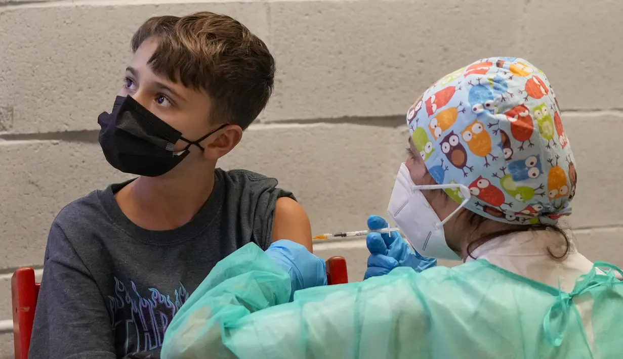 Seorang anak menerima dosis vaksin COVID-19 Pfizer-BioNTech untuk anak-anak berusia 5 - 11 tahun di Roma, Rabu (16/12/2201). Italia telah mulai memvaksinasi anak-anak berusia 5-11 tahunsaat pemerintah bersiap menghadapi penyebaran varian omicron selama musim liburan. (AP Photo/Andrew Medichini)