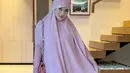 Titi Kamal kenakan busana muslim panjang pink yang menyatu dengan hijab. Penampilan cantik Titi Kamal dilengkapi dengan tas pink dari Chanel [@titi_kamall]
