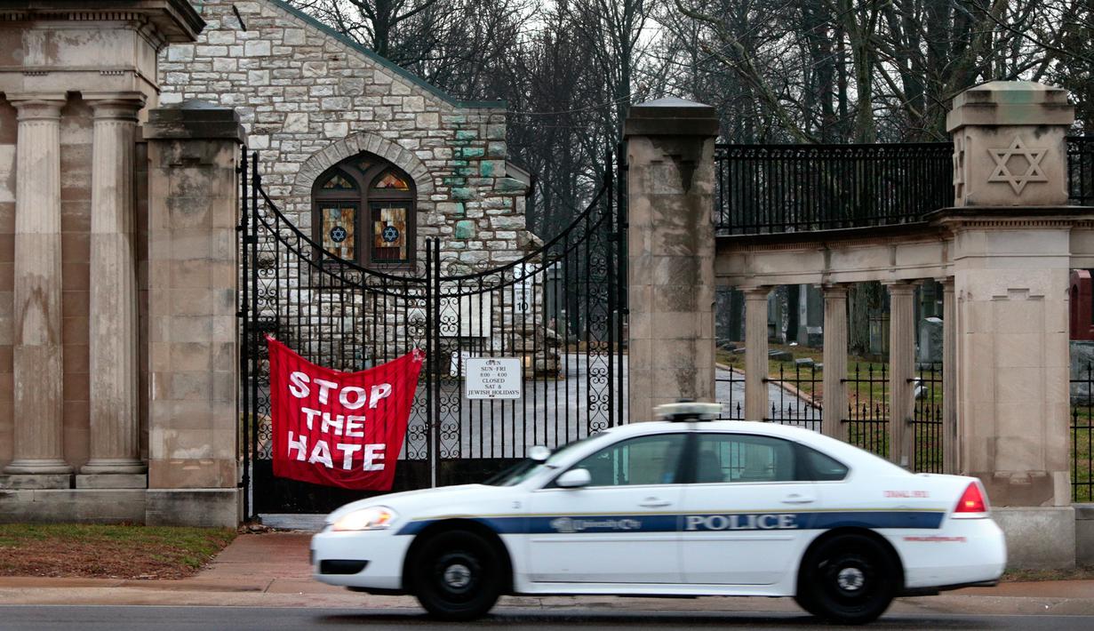 Petugas berjaga di depan gerbang Chesed Shel Emeth Cemetery di University City, St Louis, Missouri, (21/2). Otoritas Missouri sedang menyelidiki dibalik aksi vandalisme ini. (Robert Cohen /St. Louis Post-Dispatch via AP)