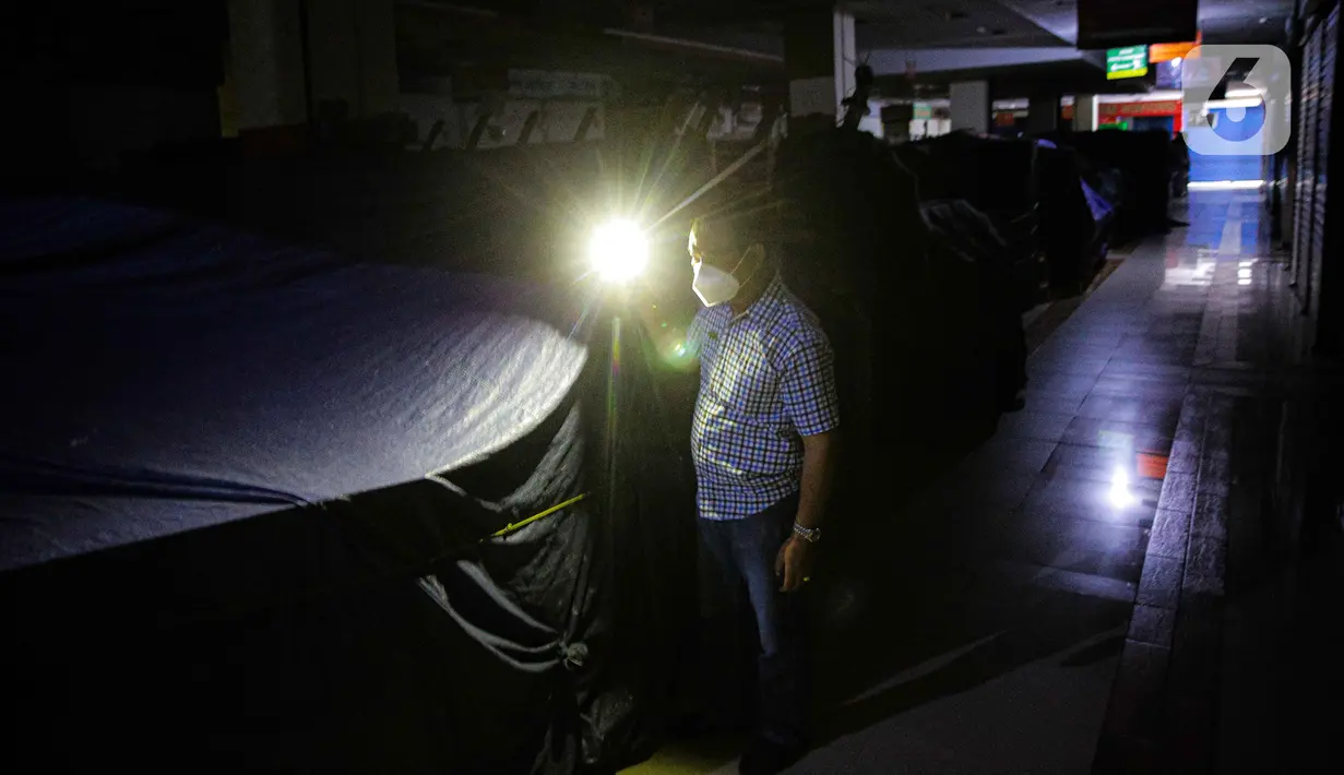 Petugas mengecek kondisi tenant tutup di Mall PGC Cililitan, Jakarta, Selasa (27/7/2021). Menurut keterangan pedagang, pemerintah harus memberikan perhatian kepada para pedagang dan pelaku UMKM di mal dan pusat perbelanjaan seiring diperpanjangnya PPKM Level 4. (Liputan6.com/Faizal Fanani)