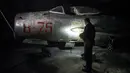 Pilot jet tempur Albania dan mantan komandan angkatan udara Fatmir Danaj (52) memeriksa jet tempur MiG-19 dalam terowongan utama Pangkalan Udara Gjader di dekat Kota Lezhe, 5 Februari 2019. (Gent Shkullaku/AFP)