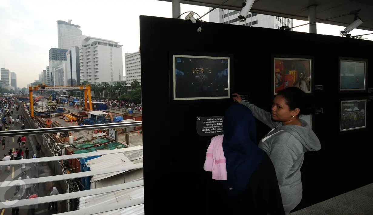 Warga melihat pameran foto kemajuan pembangunan MRT di Jembatan Penyebrangan Orang Bundaran Hotel Indonesia, Jakarta, Minggu (7/5). Pameran bertema Aku, Kamu, Kita #UbahJakarta. (Liputan6.com/Helmi Fithriansyah)