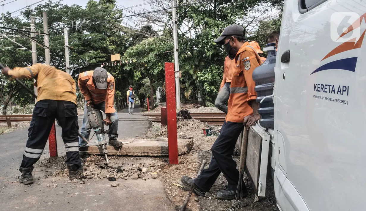 Pekerja PT KAI menyelesaikan pemasangan pembatas jalan di perlintasan kereta tanpa palang pintu di kawasan TPU Tanah Kusir, Jakarta, Kamis (17/9/2020). Pemasangan pembatas jalan dilakukan untuk mencegah kecelakaan kendaraan yang sering terjadi di kawasan tersebut. (merdeka.com/Iqbal S. Nugroho)