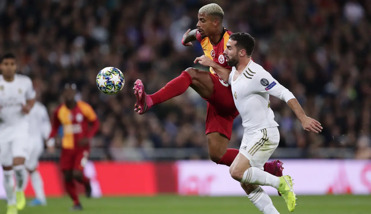 Gelandang Galatasaray, Mario Lemina berebut bola dengan bek Real Madrid, Dani Carvajal pada pertandingan Grup A Liga Champions di stadion Santiago Bernabeu, Spanyol (6/11/2019). Madrid menang telak 6-0 atas Galatasaray. (AP Photo/Manu Fernandez)