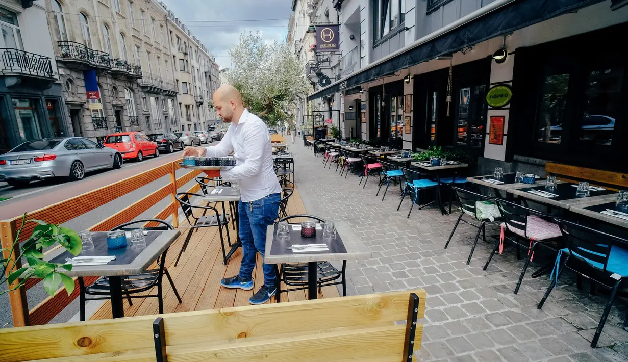 Seorang pelayan menyiapkan meja di sebuah restoran di Brussel, Belgia, Selasa  (7/7/2020). Komisi Eropa memprediksi Ekonomi Eropa akan menghadapi resesi lebih dalam akibat langkah-langkah pengendalian COVID-19 yang berkepanjangan. (Xinhua/Zhang Cheng)