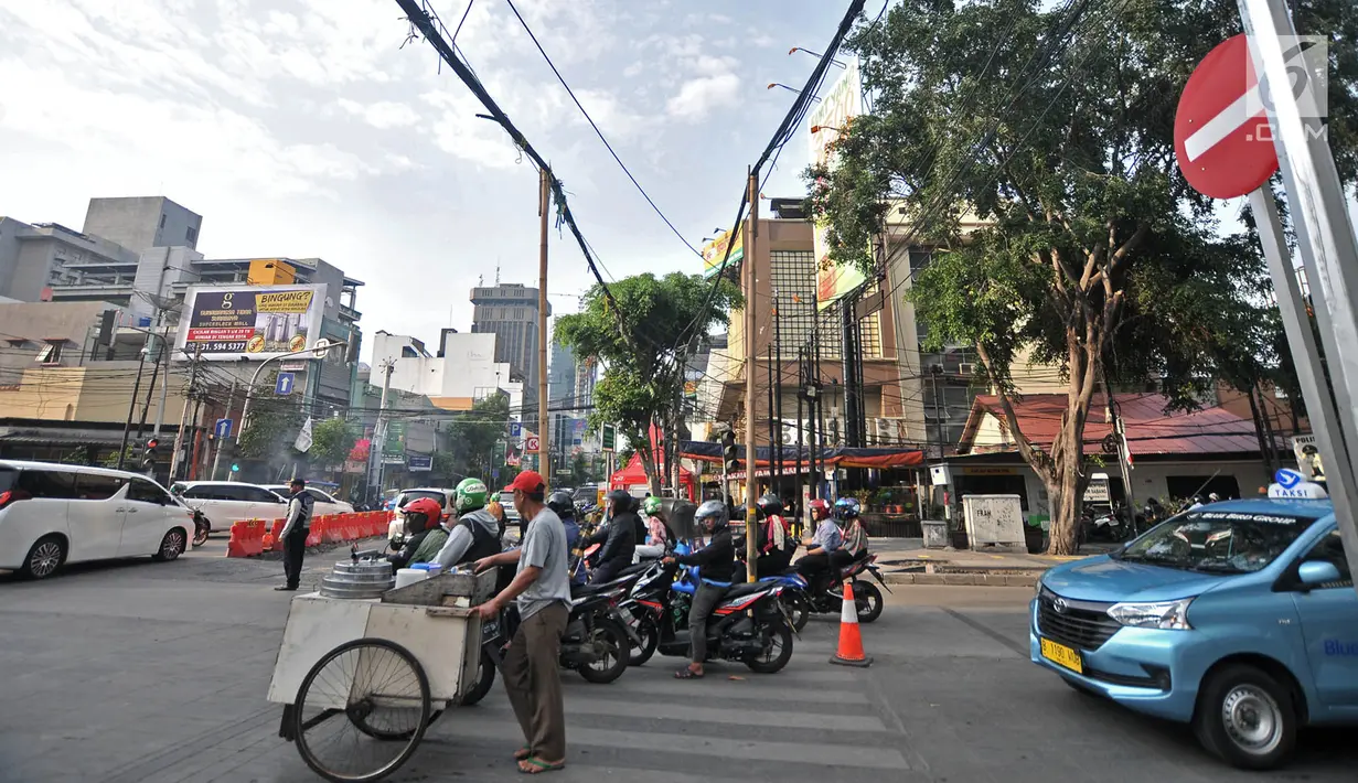 Kendaraan saat melintasi bambu penyangga kabel di Jalan Wahid Hasyim, Jakarta, Selasa (6/11). Dua buah bambu penyangga kabel menjuntai yang sudah ada sejak beberapa hari lalu tersebut berada di tengah jalan. (Merdeka.com/Iqbal S. Nugroho)