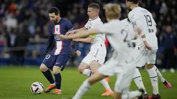 Pemain Paris Saint-Germain (PSG), Lionel Messi, berusaha melewati penjagaan ketat pemain Stade Rennes pada laga Liga Prancis di Stadion Parc des Princes, Minggu (19/3/2023). (AP Photo/Christophe Ena)