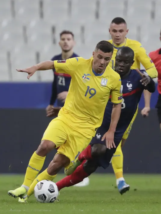 Penyerang Ukraina, Junior Moraes membawa bola dari kejaran gelandang Prancis, Ngolo Kante pada pertandingan kualifikasi Piala Dunia D di stadion Start de France, di Saint Denis, utara Paris, Kamis (25/3/2021). Prancis bermain imbang atas Ukraina 1-1. (AP Photo/Thibault Camus)