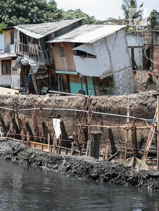 Sejumlah rumah hampir ambruk akibat amblesnya tanah di bantaran Anak Kali Ciliwung di Jalan Lodan Raya, Pademangan, Jakarta, Senin (19/11). Petugas mengungsikan warga ke tempat pengungsian sementara. (Liputan6.com/Faizal Fanani)