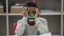 Seorang siswa mengenakan masker pada hari pertama kembali ke kelas tatap muka di tengah pandemi COVID-19 di sekolah umum Raul Antonio Fragoso di Sao Paulo, Brasil (8/2/2021). Pemerintah negara bagian Sao Paulo telah mengizinkan sekolah tatap muka. (AP Photo/Andre Penner)
