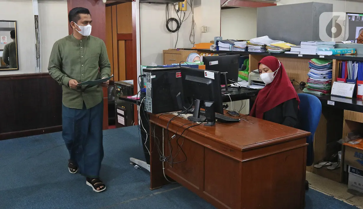 Pegawai negeri sipil (PNS) menggunakan pakaian ala santri ketika bekerja di Balai Kota Bogor, Kamis (22/4/2021). PNS di lingkungan Pemkot Bogor diwajibkan memakai pakaian ala santri setiap tanggal 22 setiap bulannya sebagai wujud penghormatan jasa para santri. (Liputan6.com/Herman Zakharia)