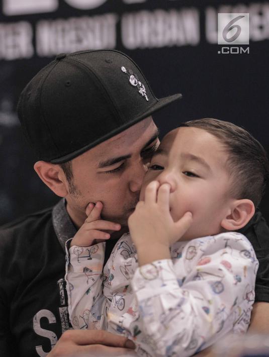 Raffi Ahmad mencium Rafatar Maliq Ahmad saat launching buku The Secret: Suster Ngesot Urband Legend di kawasan Thamrin, Jakarta, Jumat (9/2). (Liputan6.com/Faizal Fanani)