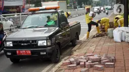 Petugas Sudin Bina Marga memerbaiki trotoar di Jalan Dr. Saharjo, Menteng Atas, Jakarta Selatan, Selasa (17/11/2020). Perbaikan trotoar dilakukan para personel satgas yang tersebar di 10 wilayah kecamatan di Jakarta Selatan. (Liputan6.com/Immanuel Antonius)