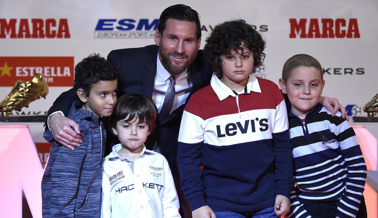 Striker Barcelona, Lionel Messi, foto bersama anak-anak saat menerima trofi Sepatu Emas Eropa di Antiga Fabrica Estrella Damm, Selasa, (18/12/2018). Messi berhak atas penghargaan itu berkat koleksi 34 gol dari 36 pertandingan. (AFP/Lluis Gene)