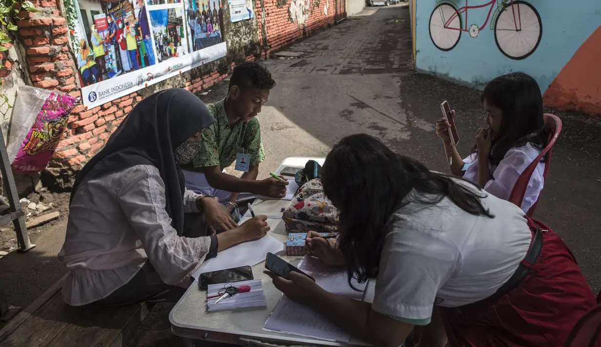 Siswa menggunakan gawai untuk mengikuti kegiatan belajar mengajar secara daring di tempat pembuangan sampah yang menyediakan WiFi gratis, di Surabaya, Rabu (15/9/2021). Belajar secara virtual itu sudah berjalan lebih dari setahun lebih di tengah pandemi Covid-19. (JUNI KRISWANTO/AFP)