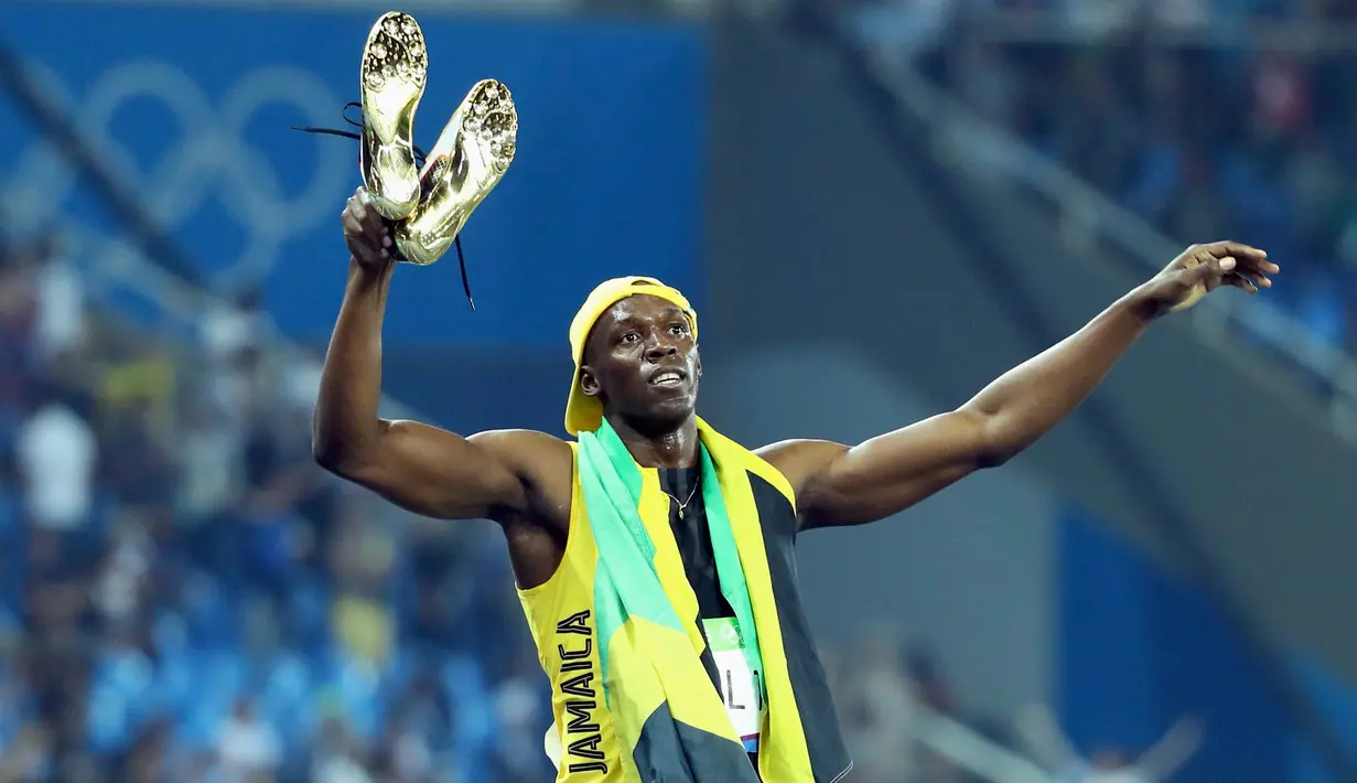  Usain Bolt melepas sepatunya saat berselebrasi usai meraih emas kategori sprint 100 meter Olimpiade 2016 di Rio de Janeiro, Brasil, (15/8). Usain Bolt berhasil meraih emas di tiga Olimpiade berturut-turut. (REUTERS/Lucy Nicholson)