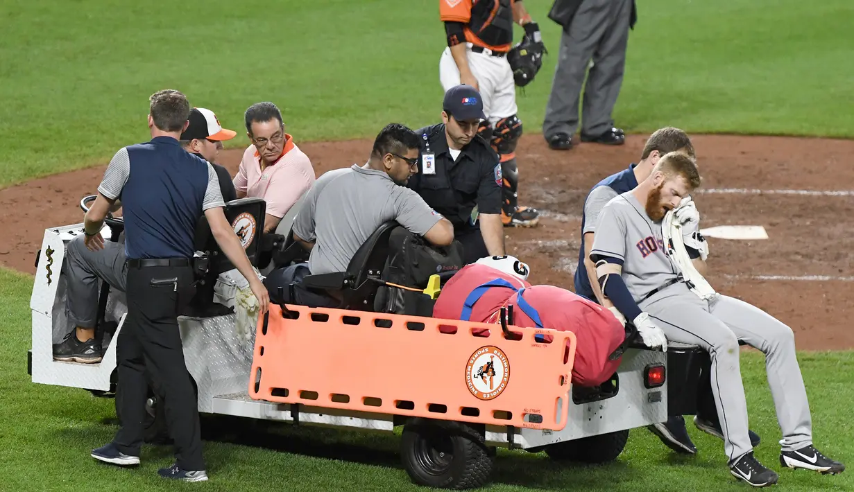 Pemain Houston Astros, Colin Moran dibawa keluar lapangan setelah bola menghantam matanya saat melawan Baltimore Orioles di Oriole Park di Camden Yards di Baltimore, Maryland (22/7). Astros menang 8-4. (Mitchell Layton/Getty Images/AFP)