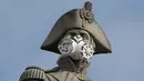 Aktivis lingkungan Greenpeace memasangkan masker pada wajah patung Nelson's Column di Trafalgar Square, pusat kota London, Senin (18/4). Aksi unik itu dilakukan untuk memprotes kualitas polusi udara di kawasan tersebut. (Leon NEAL/AFP)