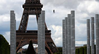 Pengunjung meluncur dengan seutas tali saat melakukan permainan Zip Line dari lantai dua Menara Eiffel di atas taman Champ de Mars, Paris, Selasa (28/5/2019). Kegiatan yang mirip dengan flying fox ini dipasangkan di atas ketinggian 115 meter dengan kecepatan 30 km per jam. (AP/Francois Mori)