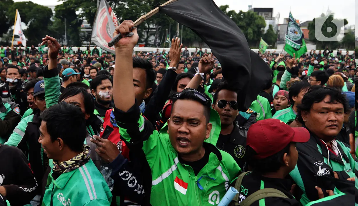 Pengemudi ojek online (ojol) menggelar demonstrasi di depan Gedung DPR/MPR, Senayan, Jakarta, Jumat (28/2/2020). Mereka menyampaikan tuntutan terkait UU No 22/2009 itu direvisi dan menjadikan kendaraan roda dua sebagai transportasi khusus terbatas. (Liputan6.com/Johan Tallo)