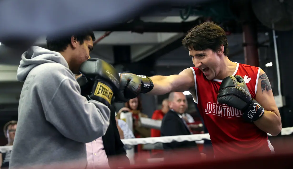 Perdana Menteri Kanada, Justin Trudeau mengarahkan pukulan ke petinju profesional Yuri Foreman di Gleason Boxing Gym di Brooklyn borough New York, AS (21/4). (REUTERS/Carlo Allegri)