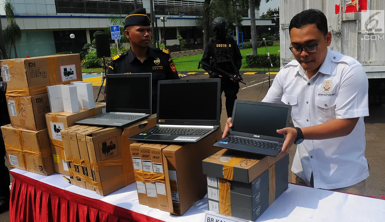 Petugas merapikan barang bukti produk elektronik ilegal saat konferensi pers di Kantor Pusat Bea Cukai, Jakarta, Selasa (30/4/2019). Barang bukti yang disita oleh Dirjen Bea dan Cukai Kemkeu adalah telepon genggam, laptop, tablet dan lainnya. (Liputan6.com/Angga Yuniar)
