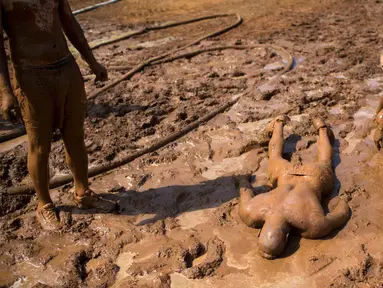 Sejumlah peserta bermandikan lumpur saat mengikuti Mud Day di Tel Aviv, Israel (24/3). Dalam acara ini para peserta harus melewati rintangan sepanjang 13 kilometer. (AP Photo/Oded Balilty)