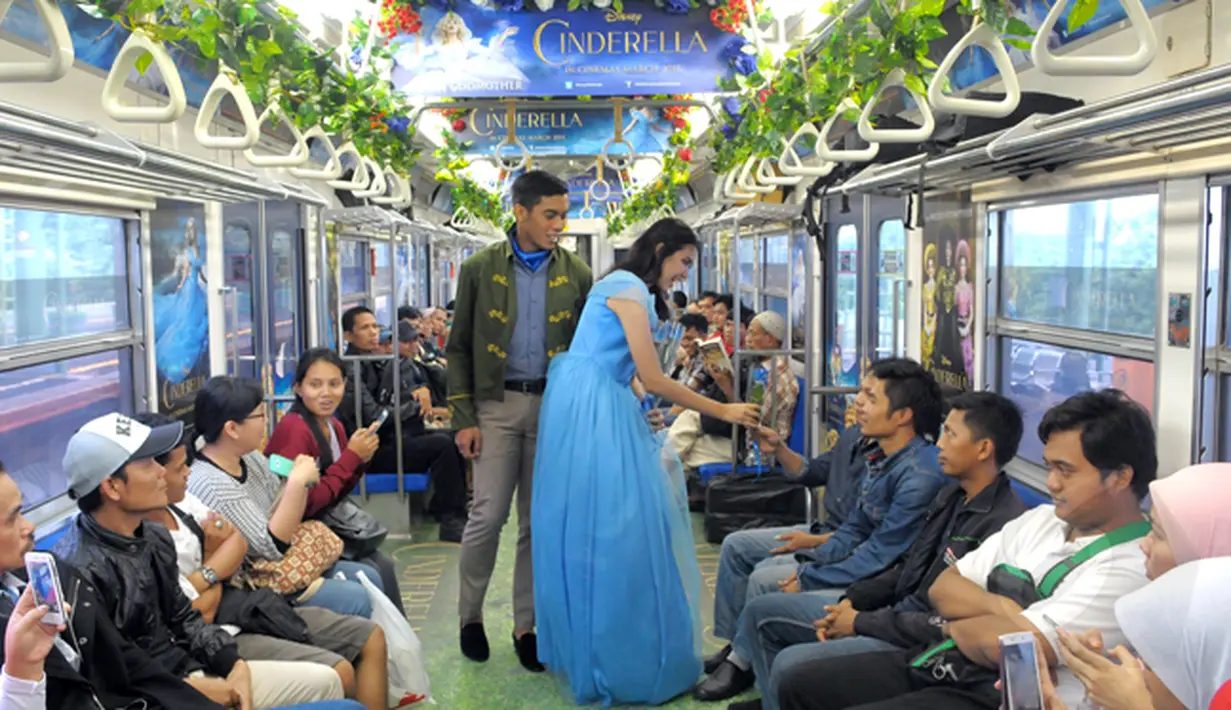 Sebuah rangkaian KRL Commuter Line didekorasi bertema film Cinderella. Tokoh dongeng Cinderella memberikan bunga pada penumpang Commuter Line Jakarta - Bogor, Jakarta, Sabtu (14/02/2015). (Liputan6.com/Andrian M Tunay)