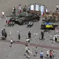 Orang-orang mengunjungi pameran terbuka tank dan kendaraan lapis baja Rusia yang rusak dan terbakar di Castle Square, di Warsawa, Polandia (27/6/2022). Kendaraan tersebut ditangkap oleh pasukan militer Ukraina selama perang di Ukraina. (AP Photo/Michal Dyjuk)