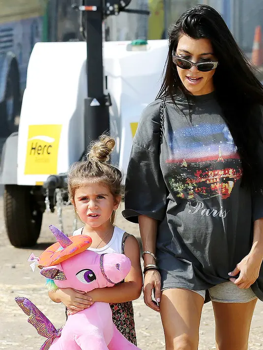 Saat jalan-jalan bareng Kourtney Kardashian, Penelope Disick memeluk erat bonekanya nih! (BROADIMAGE/REX/SHUTTERSTOCK/HollywoodLife)