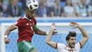 Duel pemain Maroko, Mehdi Benatia (kiri) dan pemain Iran, Iran, Karim Ansarifard pada laga grup B Piala Dunia 2018 di St. Petersburg Stadium, Rusia, (15/6/2018). Iran menang 1-0. (AP/Themba Hadebe)