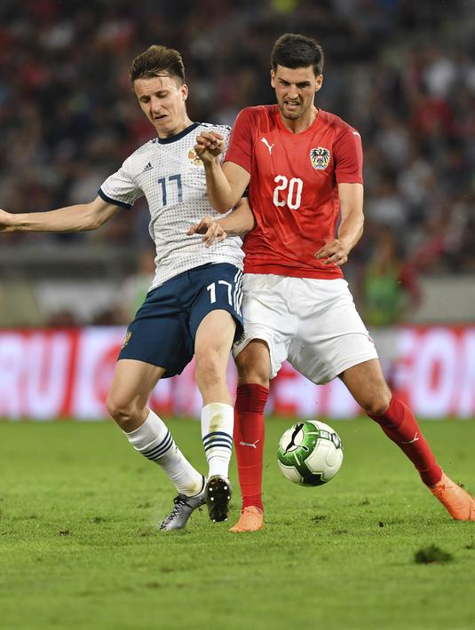 Pemain Austria, Florian Grillitsch (kanan) dan pemain Rusia saling berebut bola pada laga uji coba di Tivoli Stadium, Innsbruck, Austria, (30/5/2018). Austria menang atas Rusia 1-0. (AP/Kerstin Joensson)