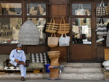Seorang pemilik toko menunggu pelanggan di Deira Souk di kota Emirat Dubai (30/9/2020). Pasar ini terbagi menjadi dua bagian, Gold Souk dan Spice Souk. (AFP/Karim Sahib)
